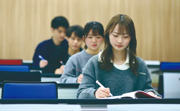 講義室で学ぶ学生